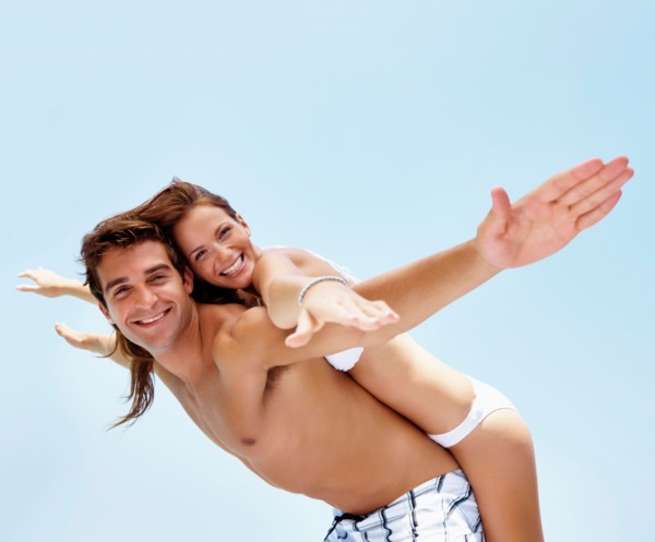 Young attractive couple enjoying summer holiday on beach
