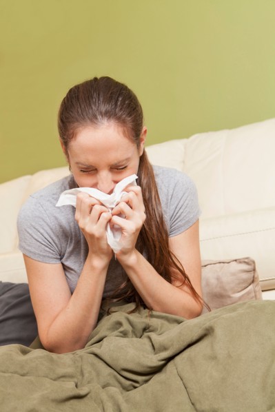 Woman on sofa blowing her nose