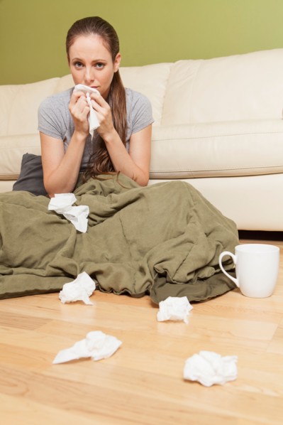 Woman in living room blowing her nose