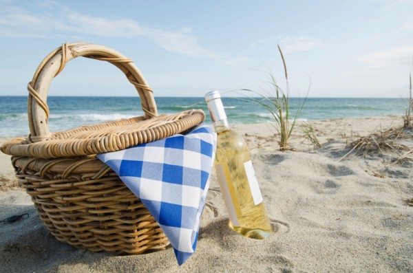Picnic basket and white wine on beach