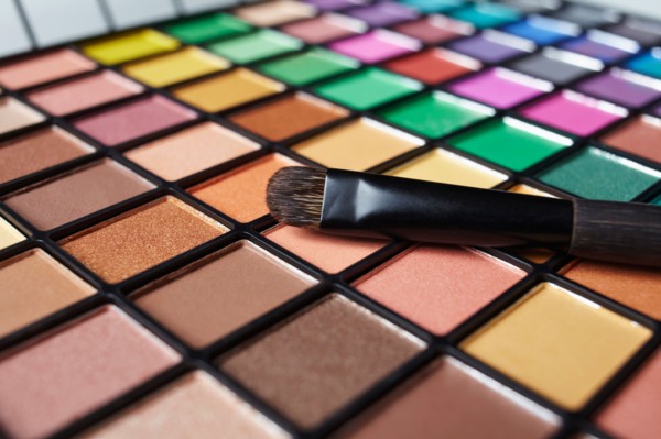 Make-up brush on eye shadow palette, studio shot