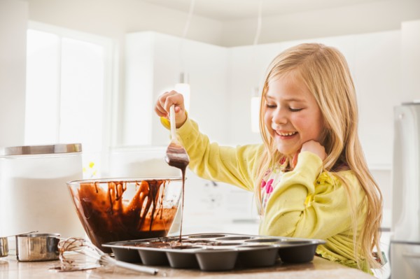 Girl (6-7) baking cupcakes