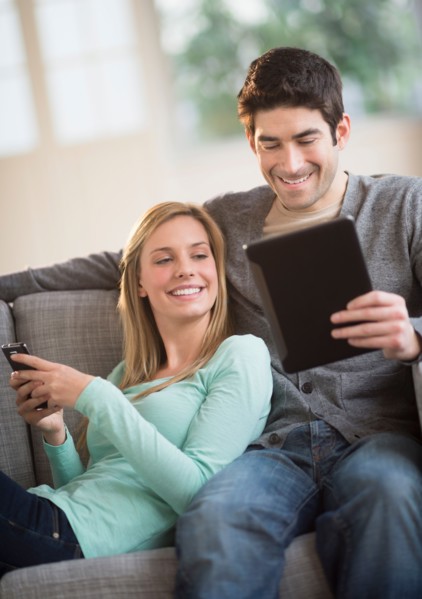 Couple using tablet pc and smartphone.