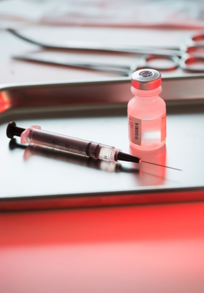 Close up of syringe and medication, studio shot.