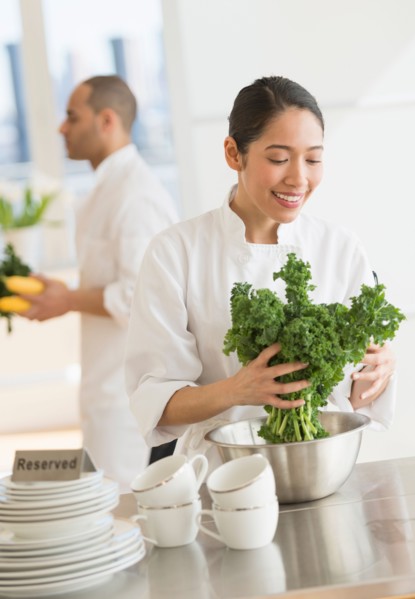 Couple during preparations in kitchen of their own restaurant.