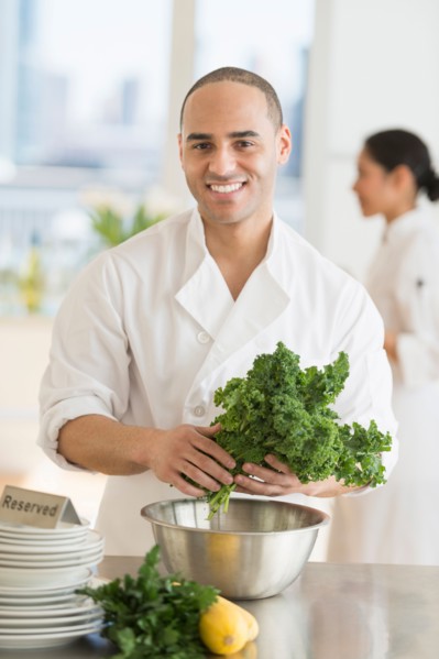 Couple during preparations in kitchen of their own restaurant.