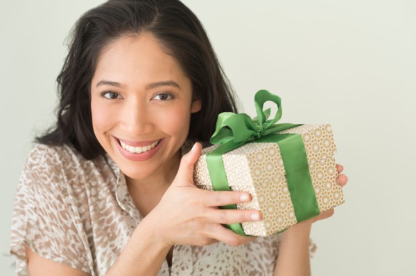 Young woman holding wrapped gift.