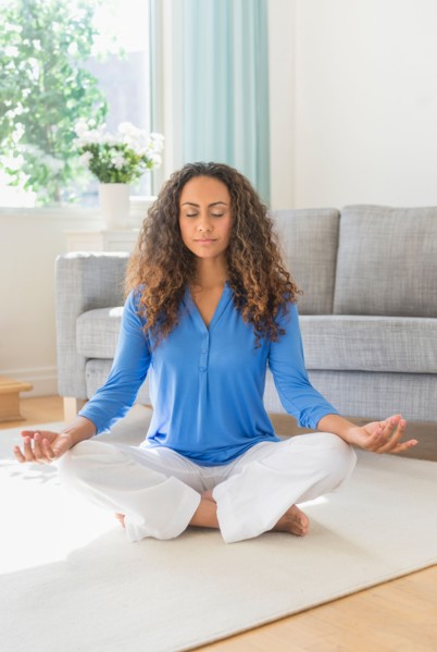 Young woman practicing yoga in living room.