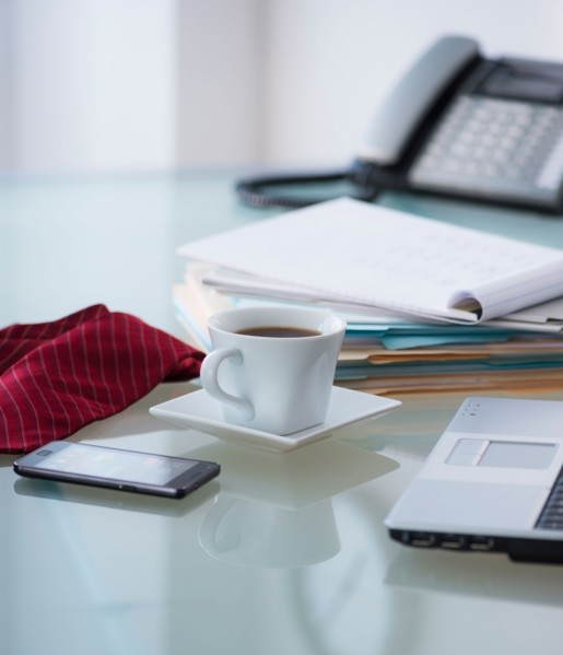 Close-up of coffee, paper material , tie, mobile phone and laptop