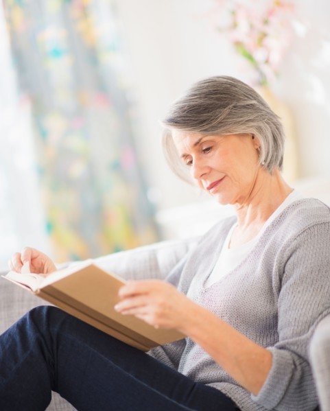 Portrait of woman reading on sofa