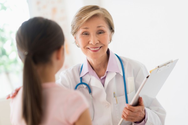 Portrait of doctor and girl (8-9) in foreground.