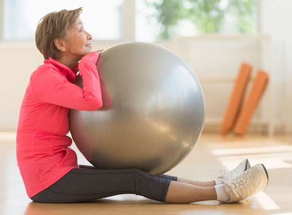 Senior woman exercising with fitness ball.