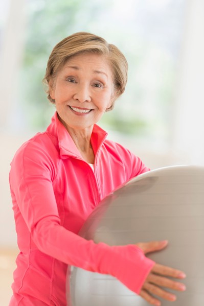 Senior woman exercising with fitness ball.