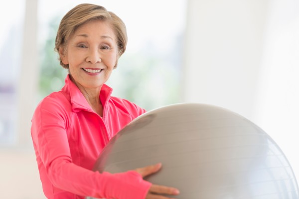 Senior woman exercising with fitness ball.