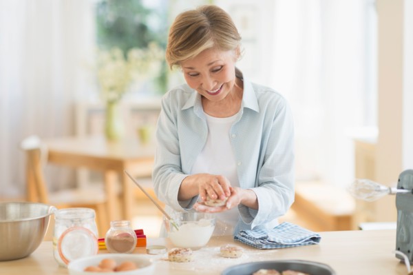 Senior woman cooking in kitchen.