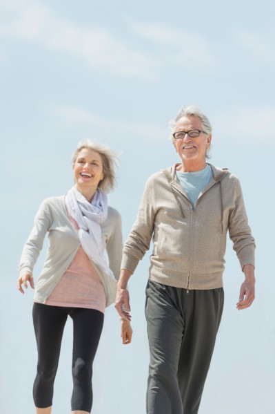 Senior couple walking and holding hands.