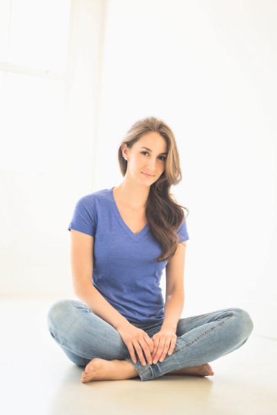 Portrait of young woman sitting on floor.