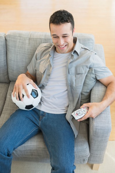 Young man watching soccer match on tv.