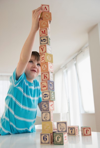 Portrait of boy (4-5) building tower