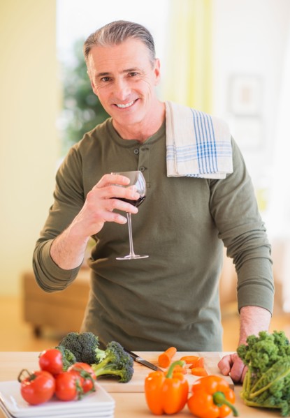 Portrait of man in kitchen, holding wine glass