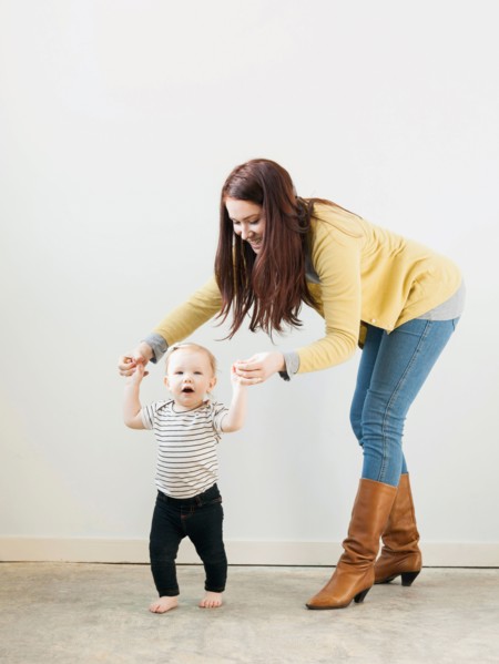 Baby girl (12-17 months) walking while mother assisting her