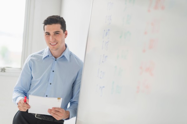 Businessman standing next to whiteboard.