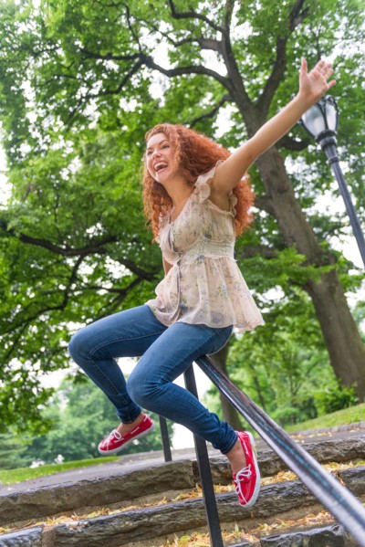Central Park, New York City. Woman sliding on railing in park.