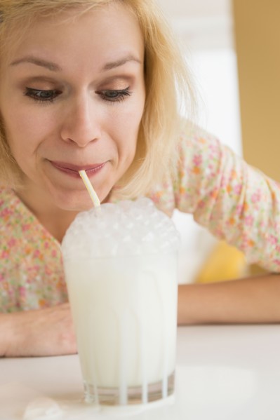 Portrait of woman blowing bubbles in milk
