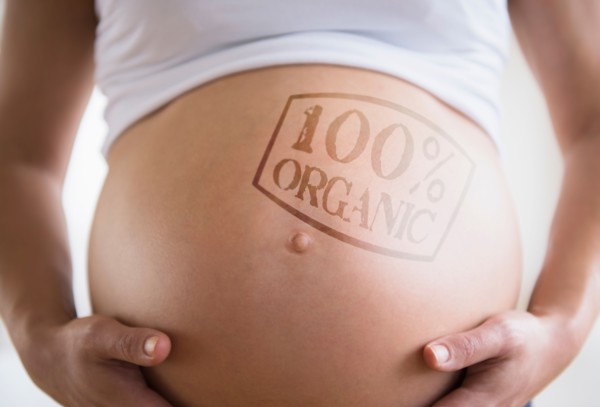 Mid section of pregnant woman with label on belly