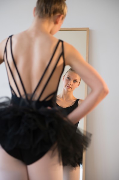 Rear view of teenage (16-17) ballerina looking into mirror