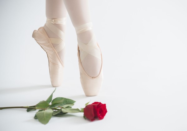 Close up of girls (16-17) ballet shoes with red rose