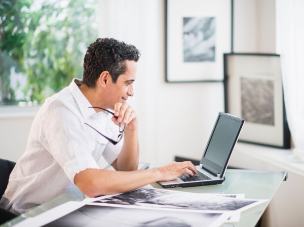 Portrait of man in his photography studio using laptop