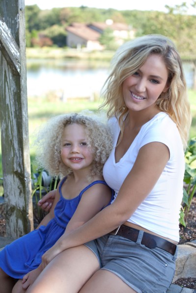 Mother with daughter (4-5) sitting outdoors