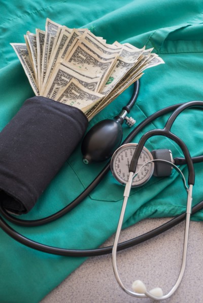Studio shot of blood pressure monitor with money.