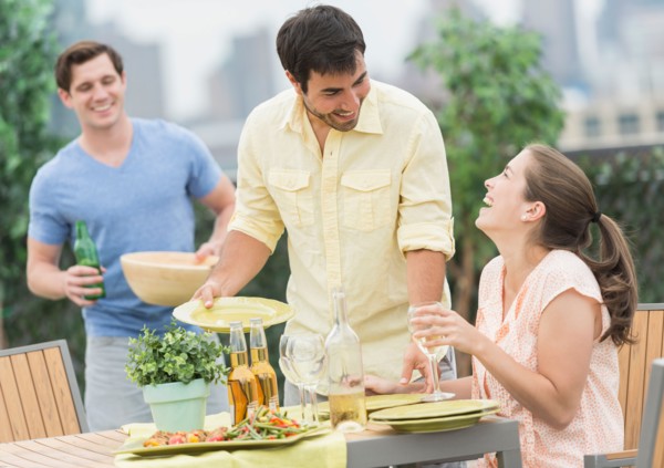 Friends enjoying barbecue in garden.