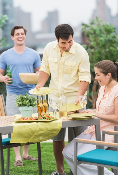 Friends enjoying barbecue in garden.