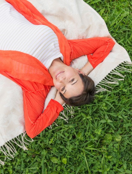 Mature woman lying on grass.