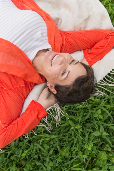 Mature woman lying on grass.