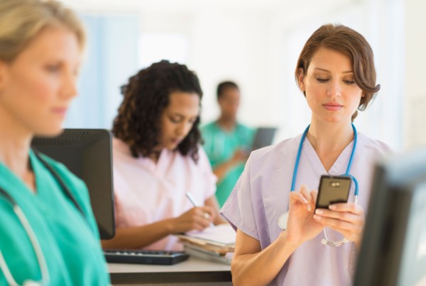 Doctors and nurses working at desks in hospital.