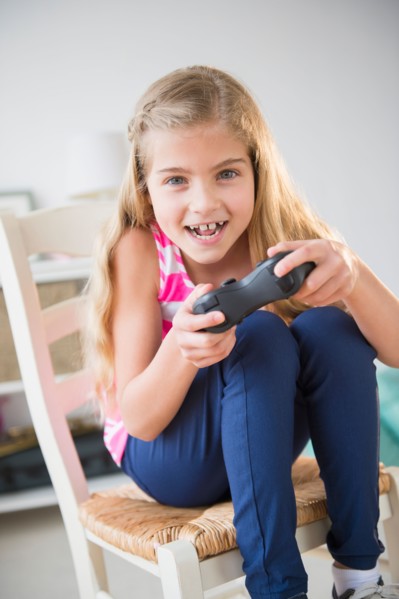 Girl (8-9) playing video game