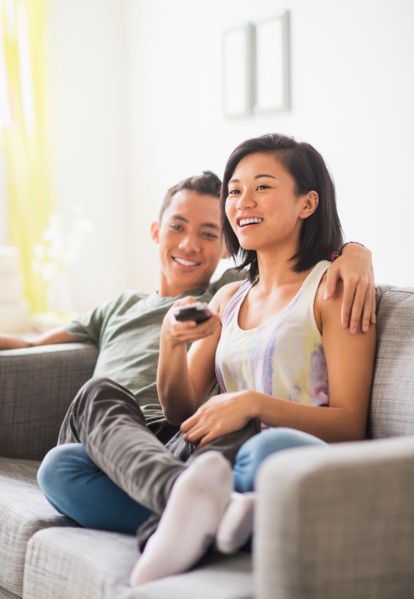 Young woman and young man sitting on sofa