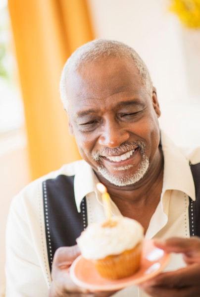 Portrait of man holding cupcake with candle