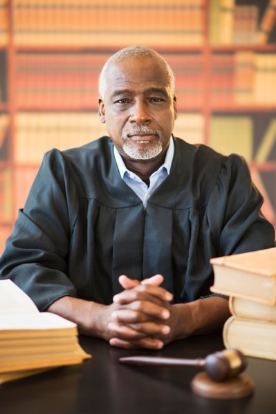 Portrait of judge in courtroom, gavel in front