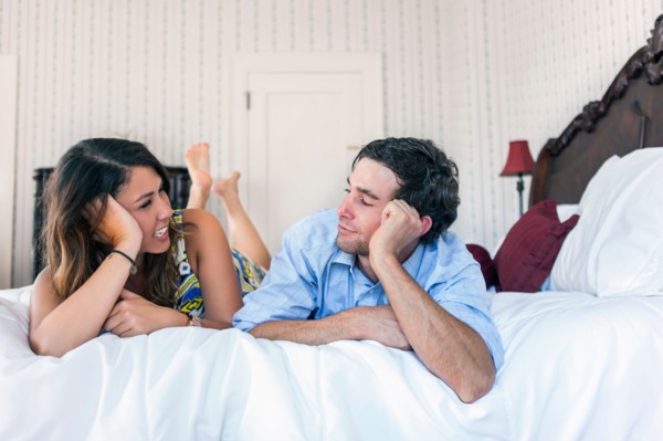 Young couple lying on bad in hotel room
