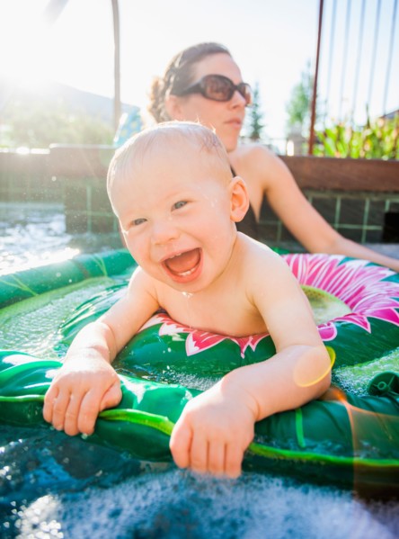 Baby boy (18-23 months) playing in swimming pool with his mother