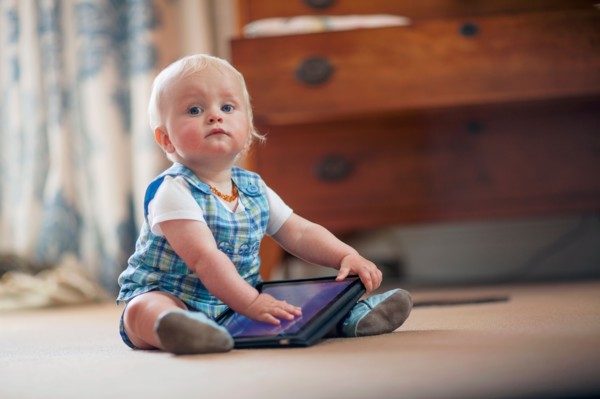 Baby boy (12-17 months) playing with digital tablet
