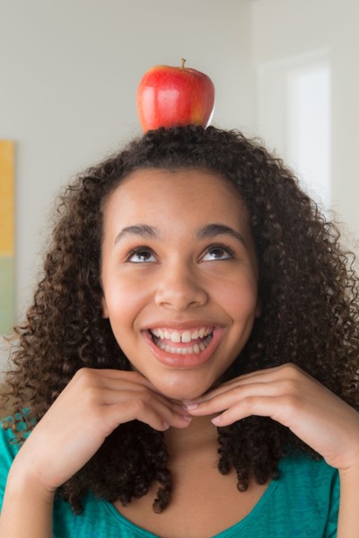Girl (-12-13) carrying apple on her head