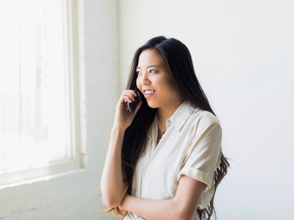 Smiling young woman talking via mobile phone
