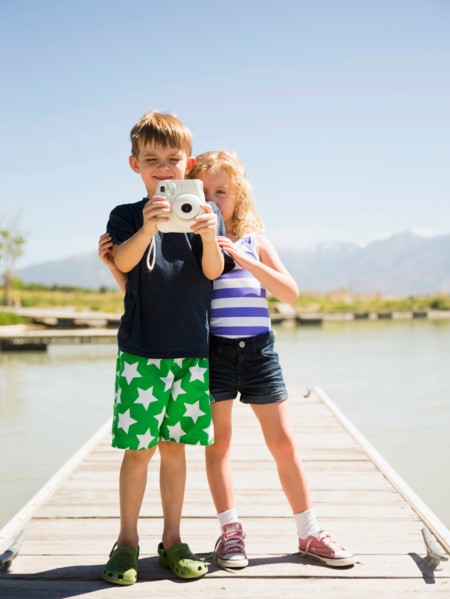 Two kids (4-5, 6-7) holding camera on pier