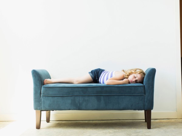 Girl (4-5) sleeping on bench indoors